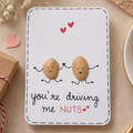Handmade funny love greeting card featuring two cute peanut characters holding hands with the message “You’re Driving Me Nuts”.